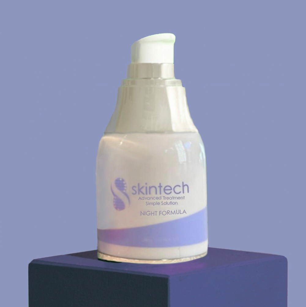 a bottle of Skintech night cream sitting on a dark blue box with a light blue background